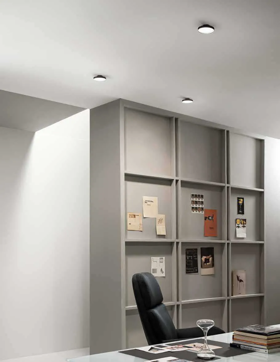 Plafoniere Shift Pan Fan Europe nere in uno studio con libreria e poltrona