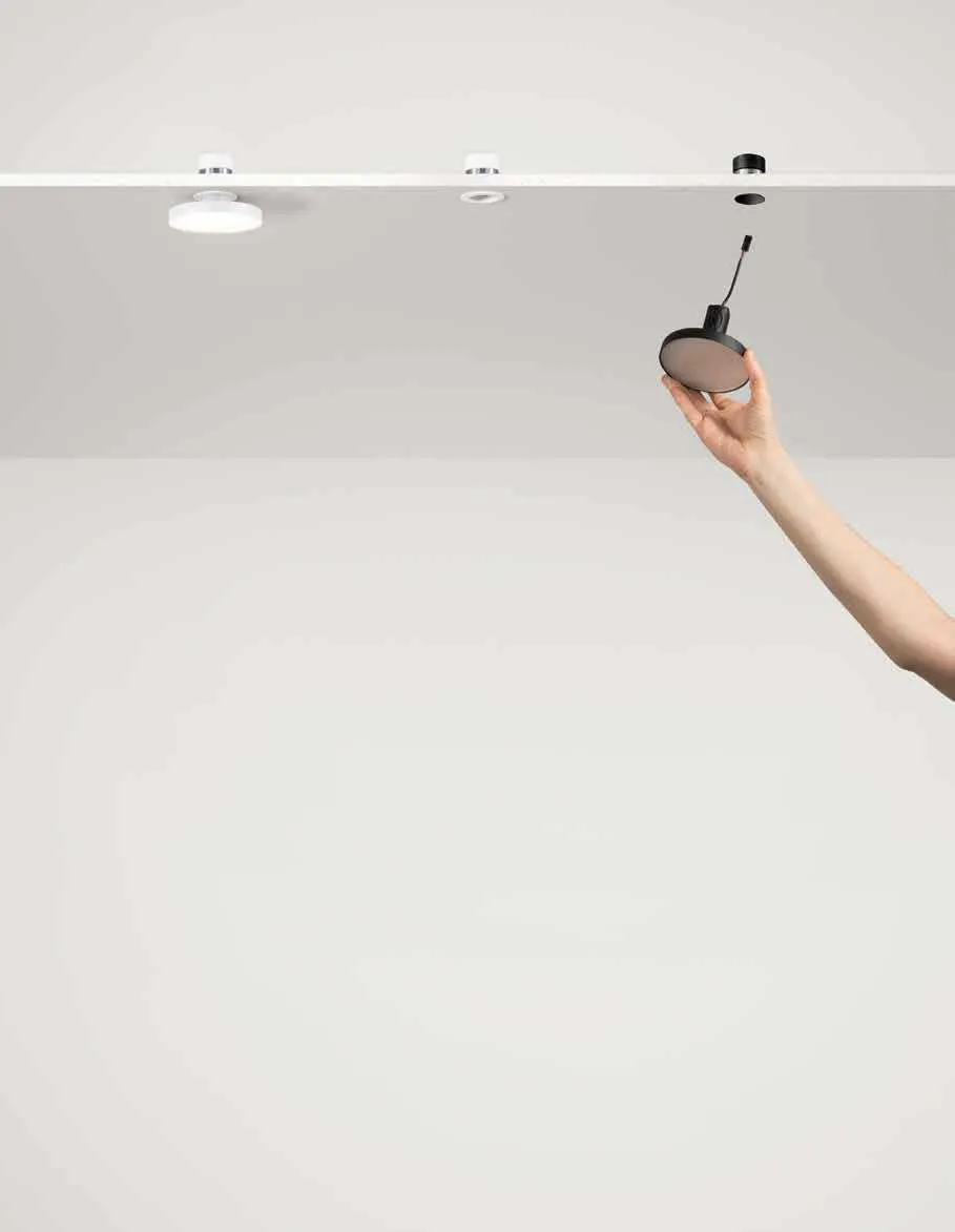 Mano che inserisce la plafoniera Shift Pan Fan Europe nel soffitto accanto a un'altra bianca
