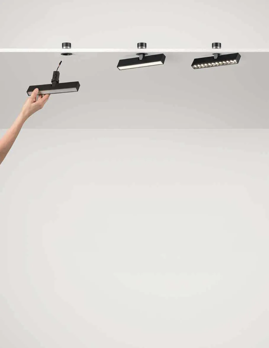 Tre lampade Shift Line Fan Europe a soffitto, una orientata con la mano