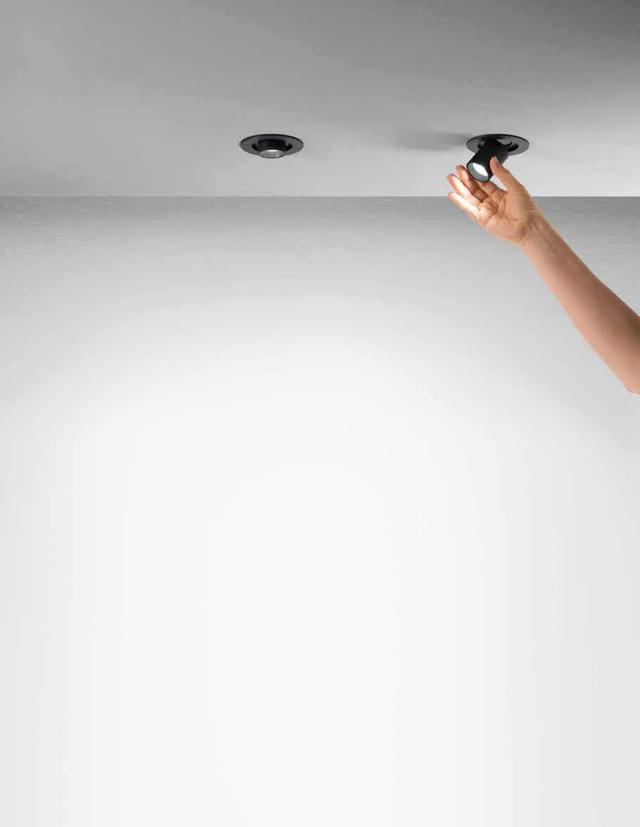 Mano che orienta un faretto da incasso Sider Fan Europe nel soffitto bianco