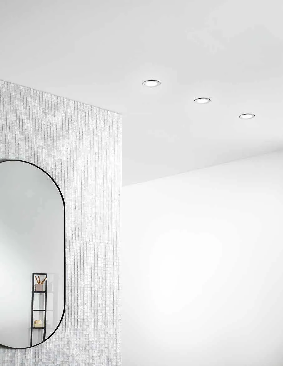 Bagno bianco con specchio ovale e faretti da incasso Rainbow Fan Europe a soffitto