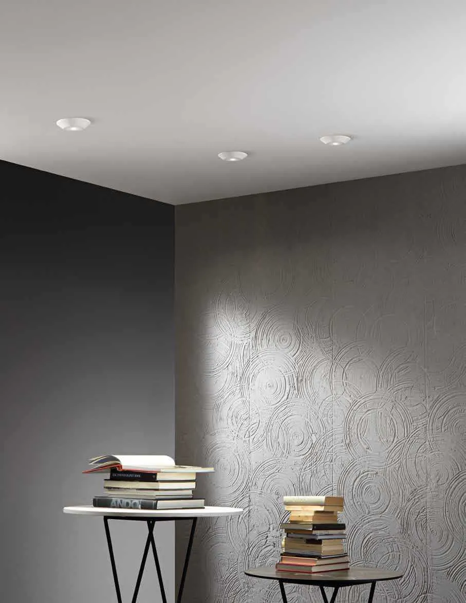Faretti LED da incasso Hall Fan Europe in un soffitto chiaro sopra due tavolini con libri