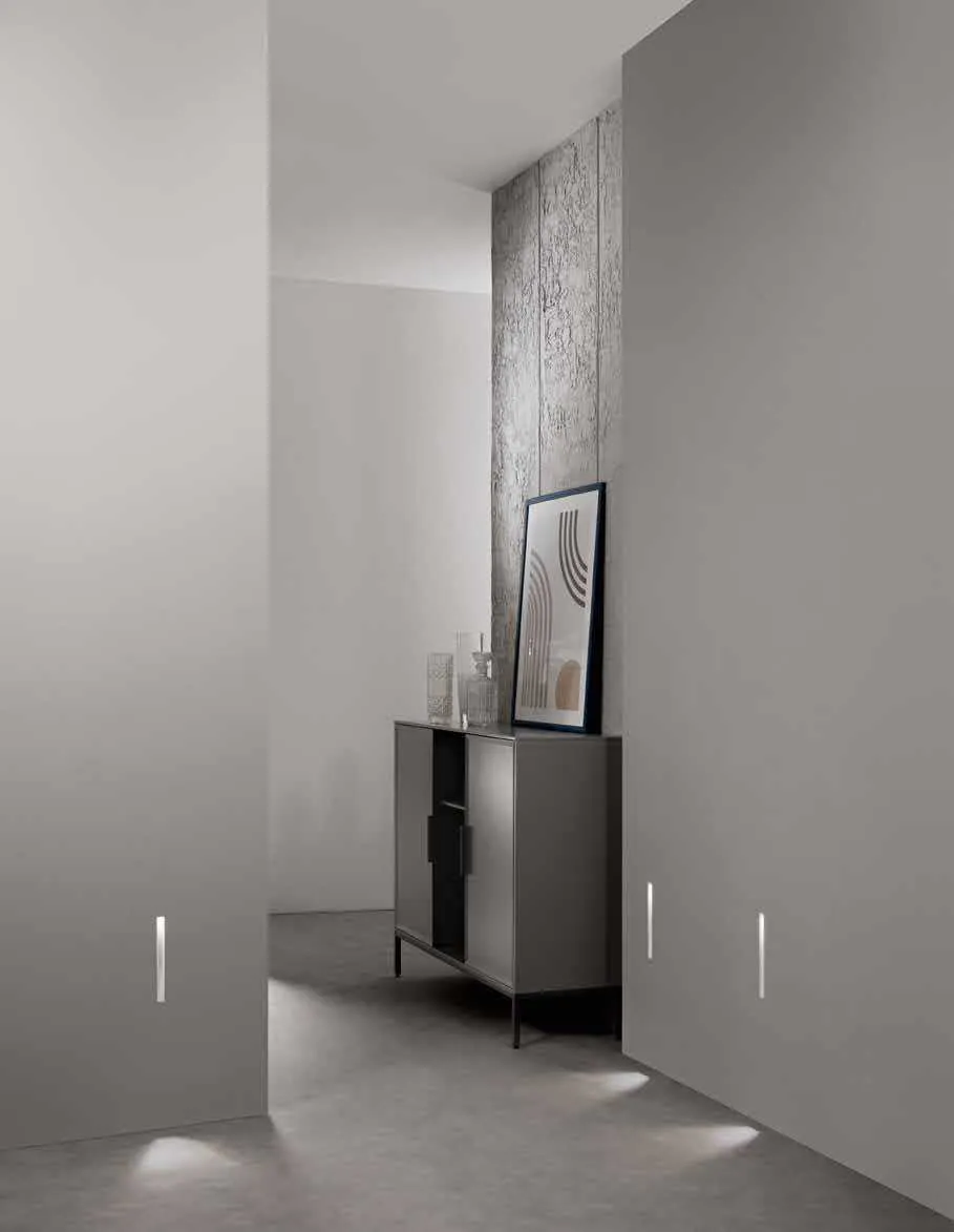 Segnapasso Elle Fan Europe con fessure di luce nella parete di un corridoio