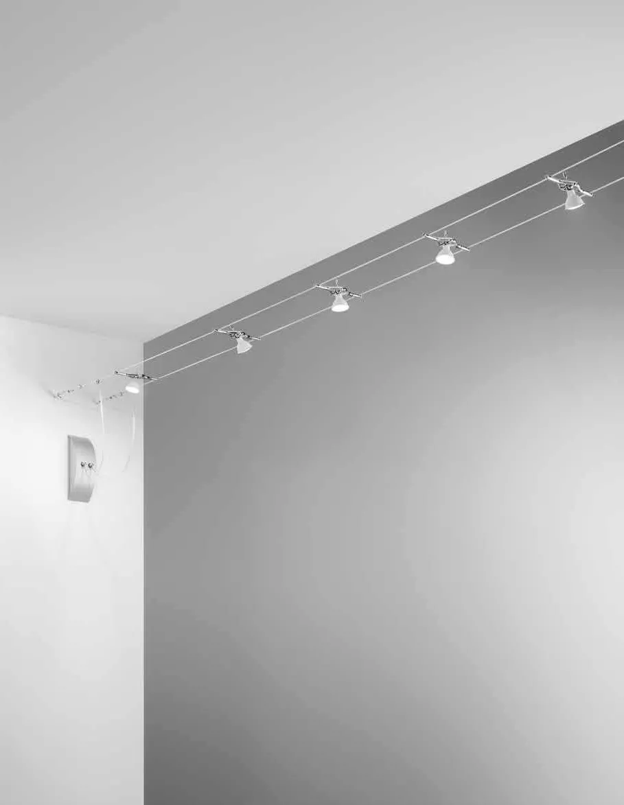 Sistema a cavi tesi Metro Fan Europe con faretti cromati lungo una parete bianca