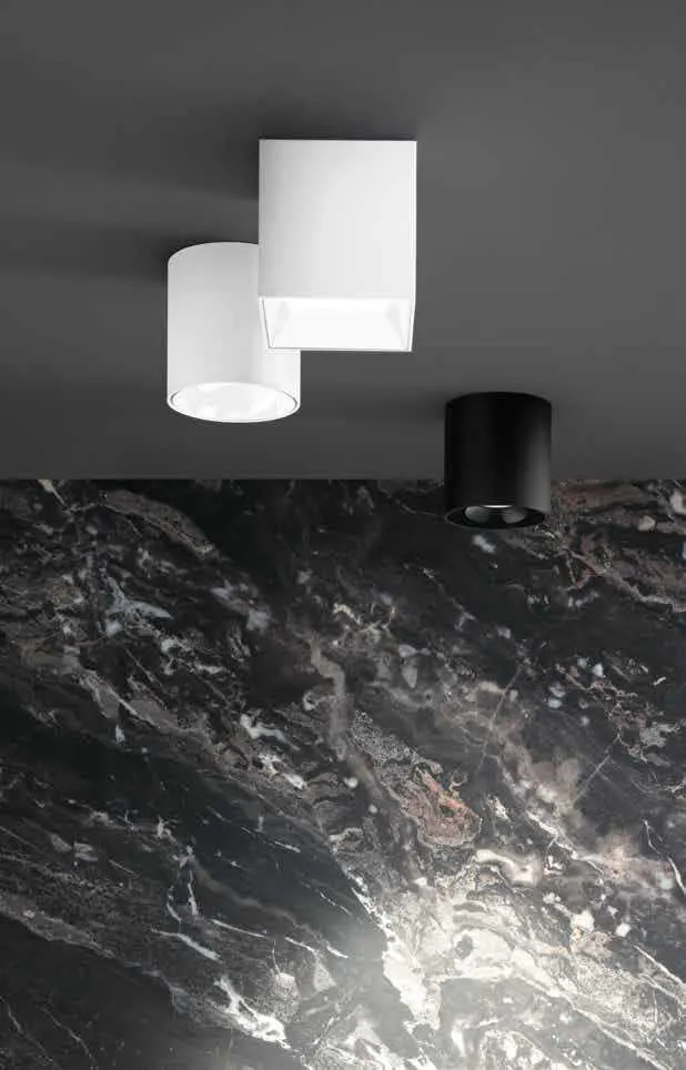 Plafoniere LED Mig Fan Europe bianca e nera sopra un piano in marmo scuro