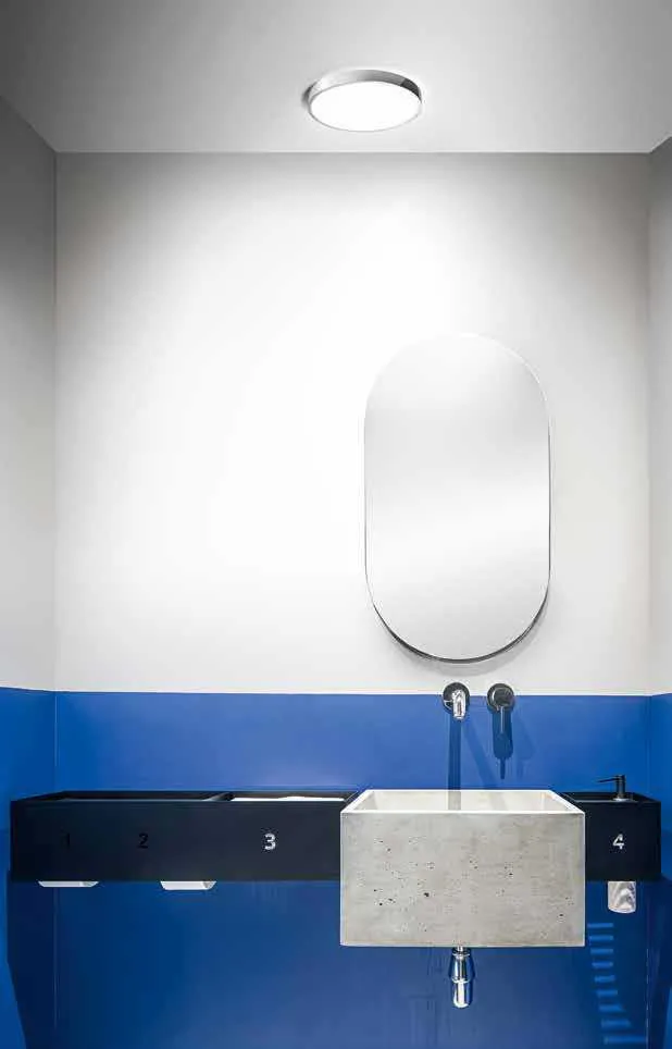 Plafoniera LED Domo Fan Europe tonda nel soffitto di un bagno con lavabo in pietra
