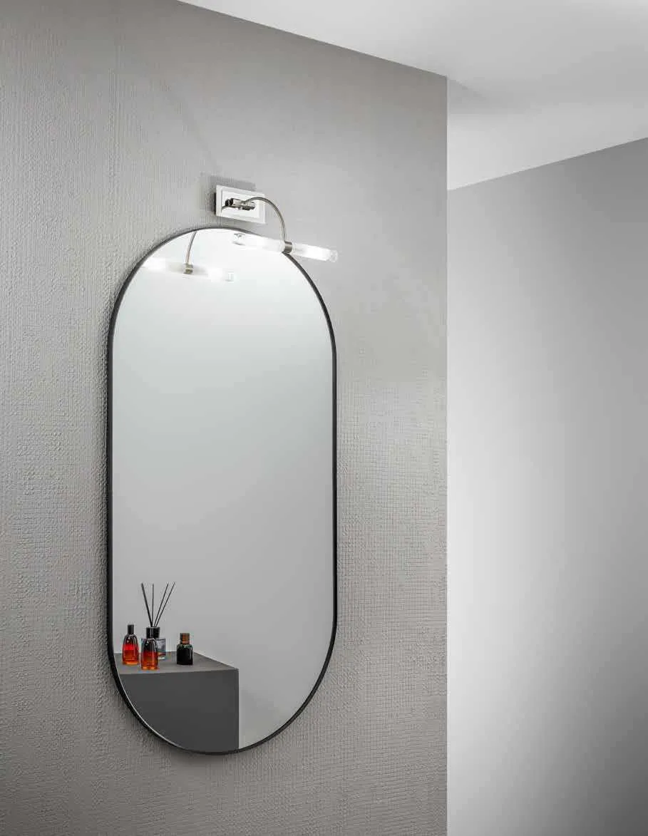 Applique Q1 Fan Europe cromata a due luci sopra uno specchio ovale in un bagno