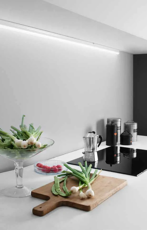 Barra LED sottopensile T5 Fan Europe accesa sopra un piano cucina con verdure