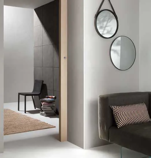 Spigolo illuminato dal profilo Ridge Fan Europe accanto a una poltrona e due specchi tondi