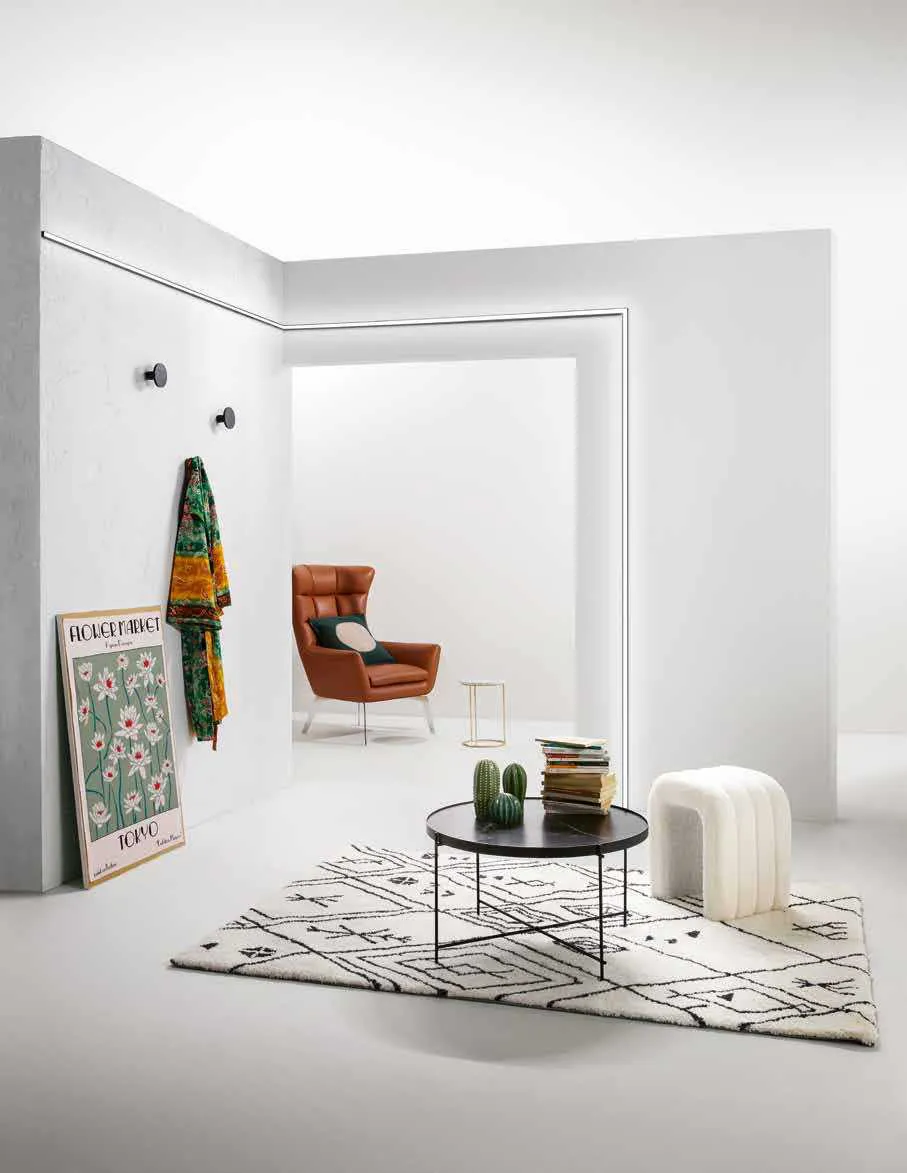 Profilo Linea Fan Europe a soffitto in un soggiorno con poltrona arancio e tappeto