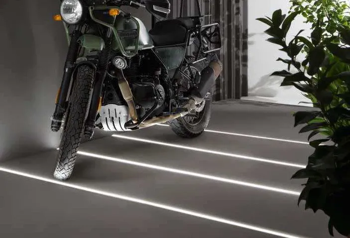 Linee di luce Driveway Fan Europe incassate nel pavimento di un garage con moto