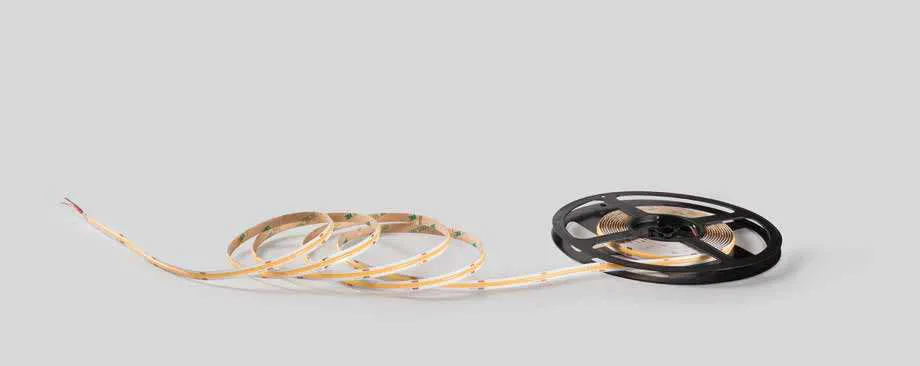 Rotolo di strip LED 24V COB 480 Fan Europe srotolato su fondo grigio