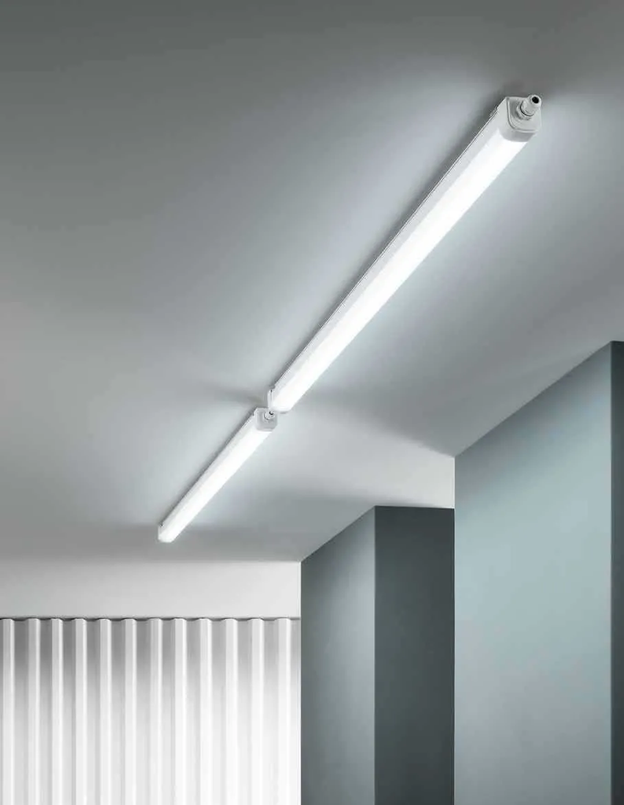 Plafoniere LED stagne Rubis Fan Europe accese su soffitto e parete di un corridoio