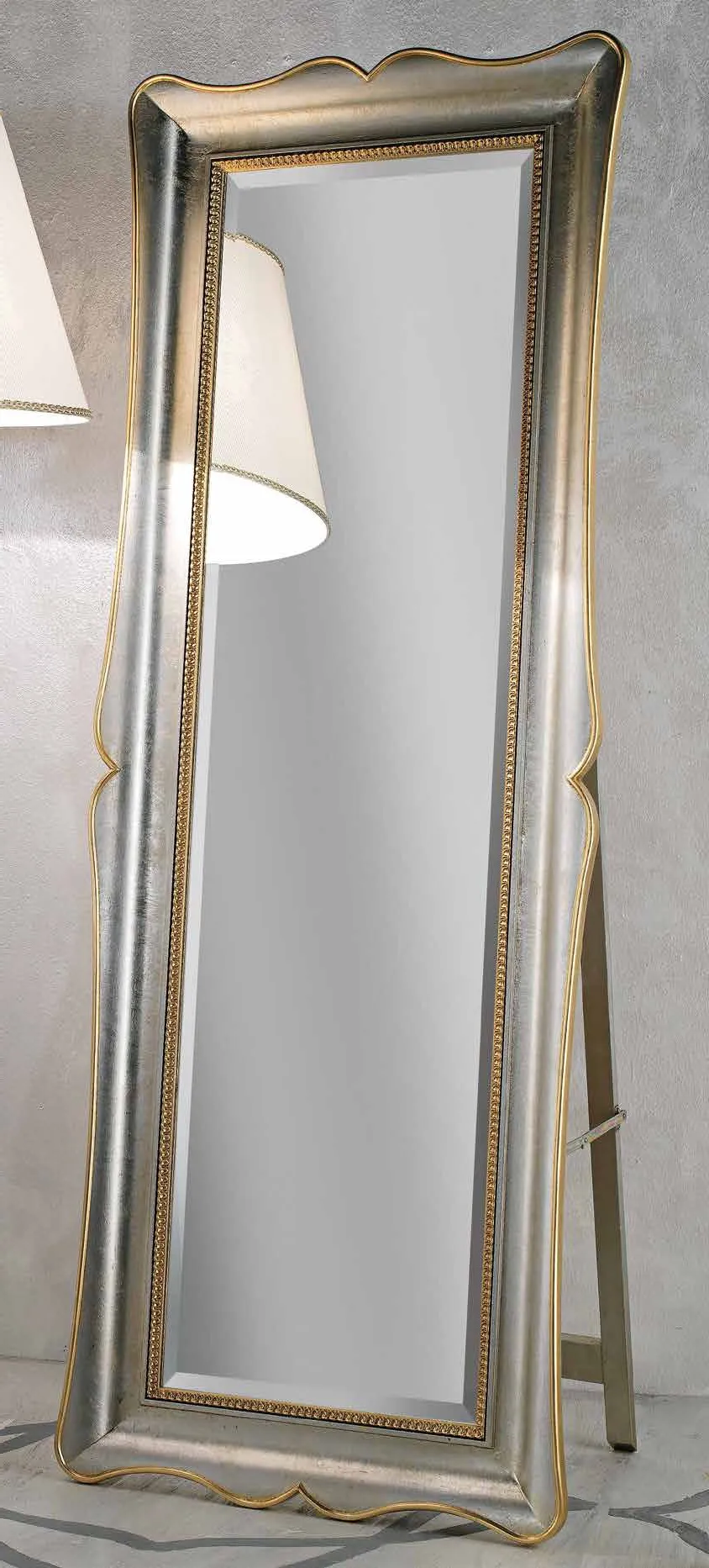 Specchiera SP 6460 Imba verticale argentata sagomata accanto a una lampada