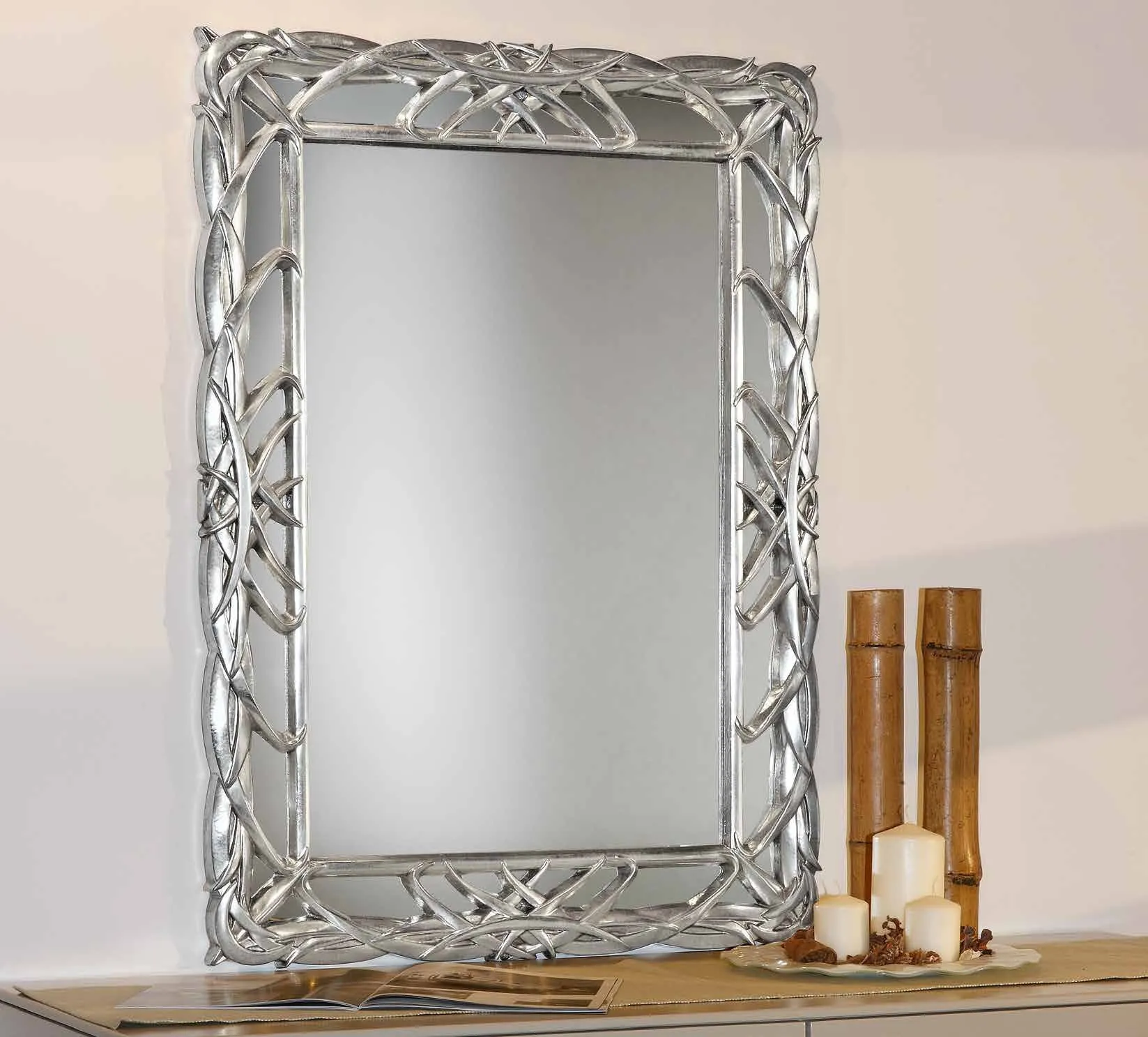 Specchiera PL 5060 Imba argento con cornice a nastri intrecciati sopra un mobile