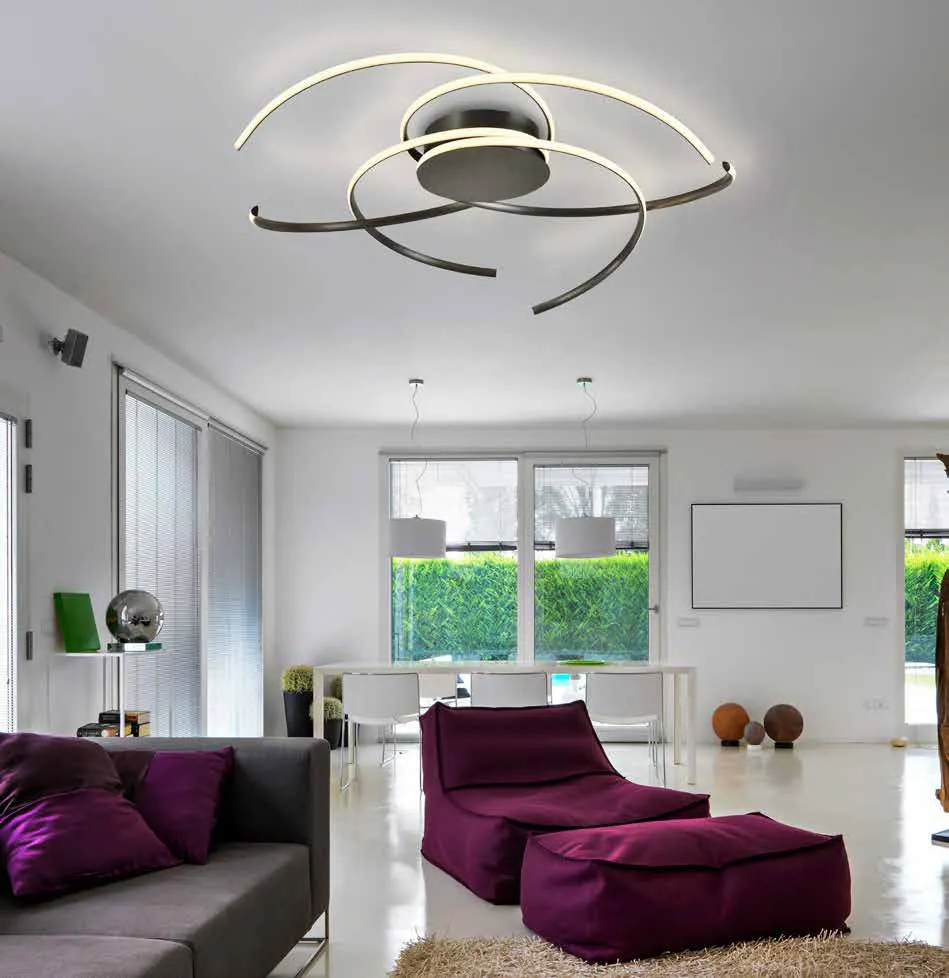 Plafoniera Cadence Schuller ad archi neri in un soggiorno con pouf viola