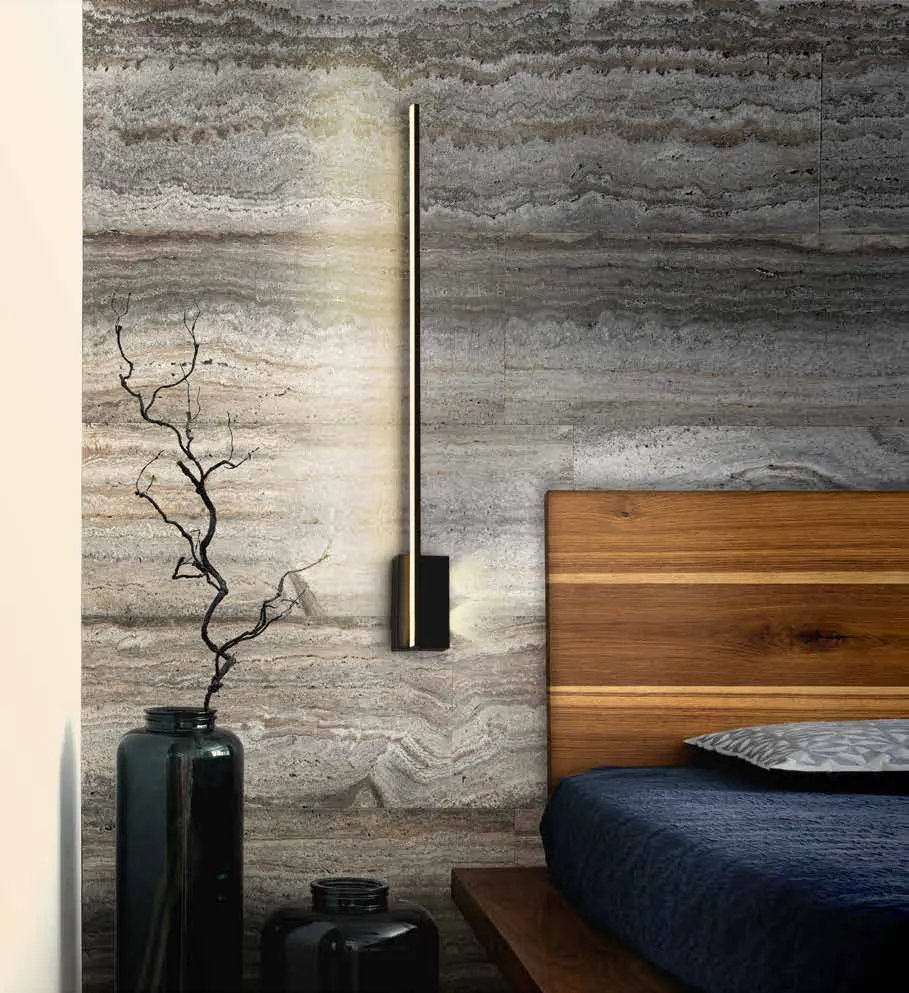 Applique Stick Schuller nera accanto alla testata di un letto