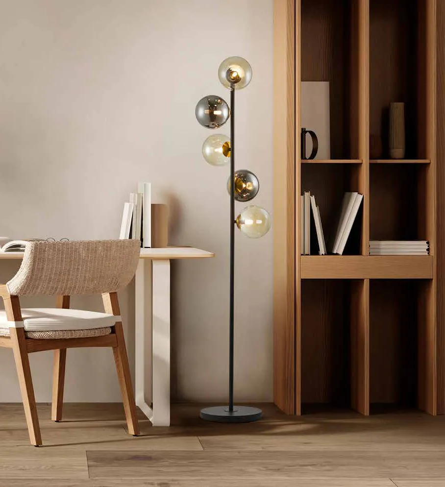Lampada da terra Inoa Schuller con sfere ambra e fumé accanto a una libreria in legno
