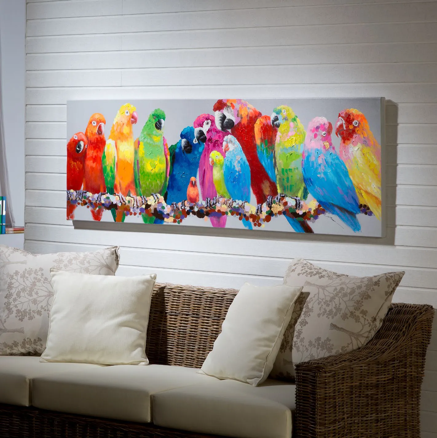 Quadro Tropic Schuller con pappagalli colorati sopra un divano bianco