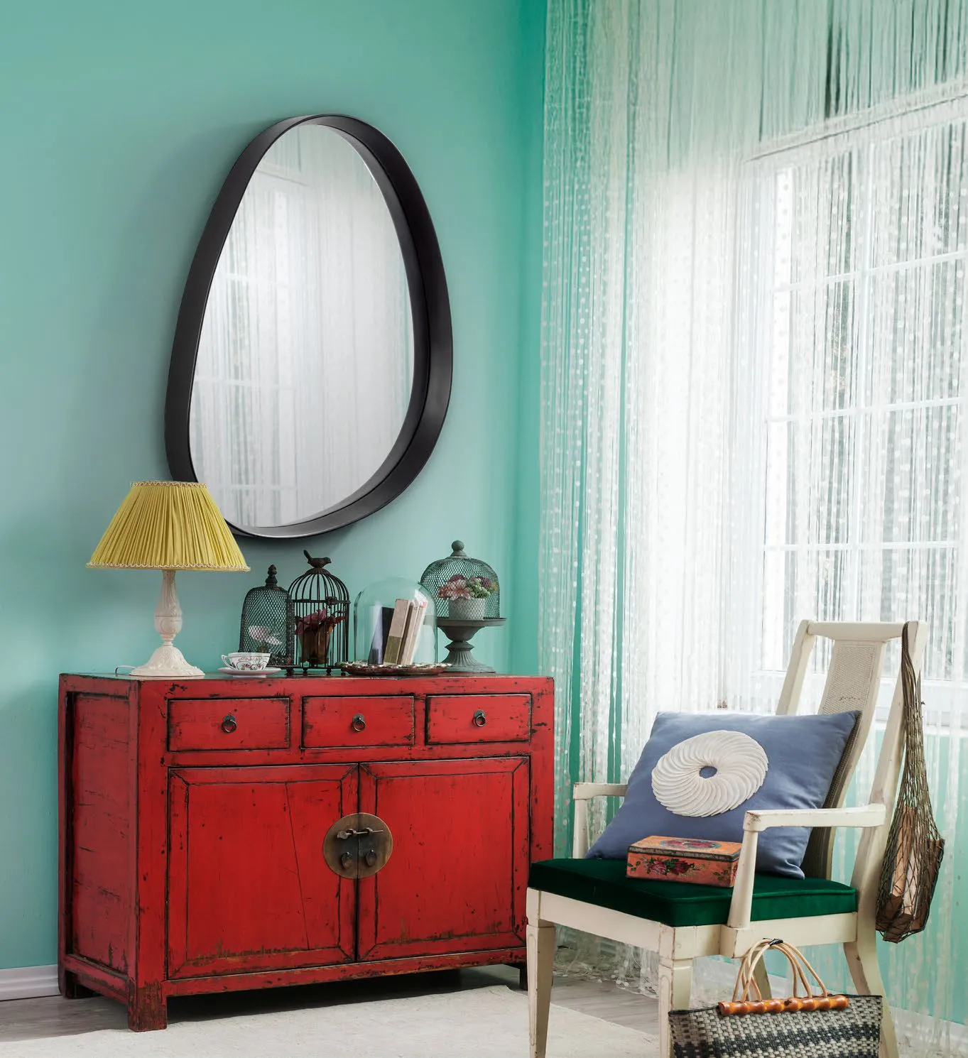 Specchio Gina Schuller nero sopra una credenza rossa