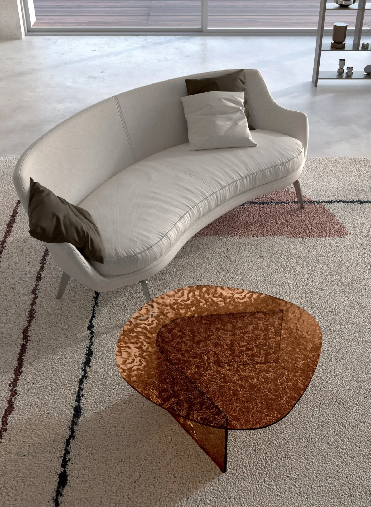 Tavolino Fold Stones in vetro bronzo accanto a una poltrona curva in un living chiaro