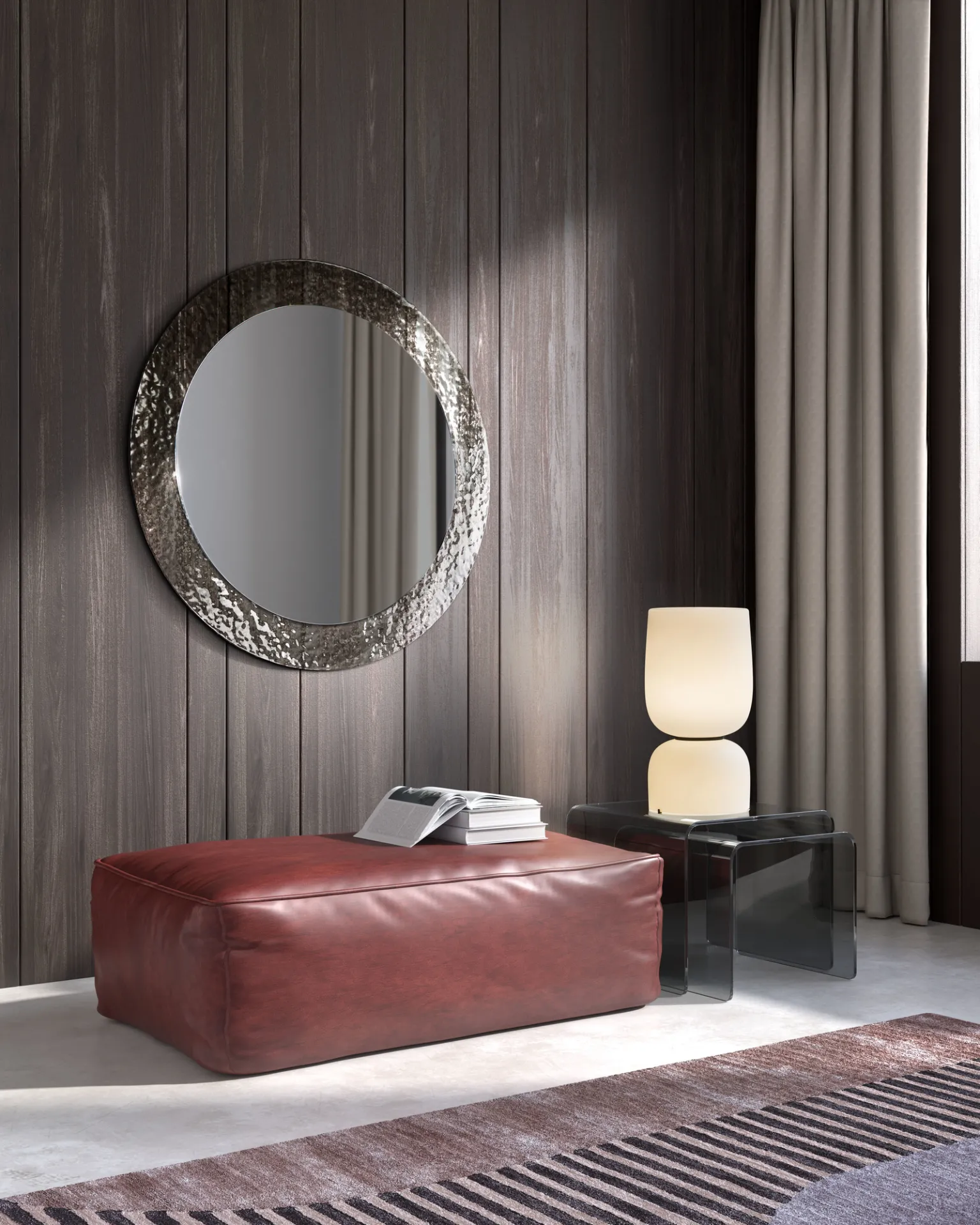 Specchio Iride Stones con cornice bronzo sopra una panca rossa in un ambiente scuro