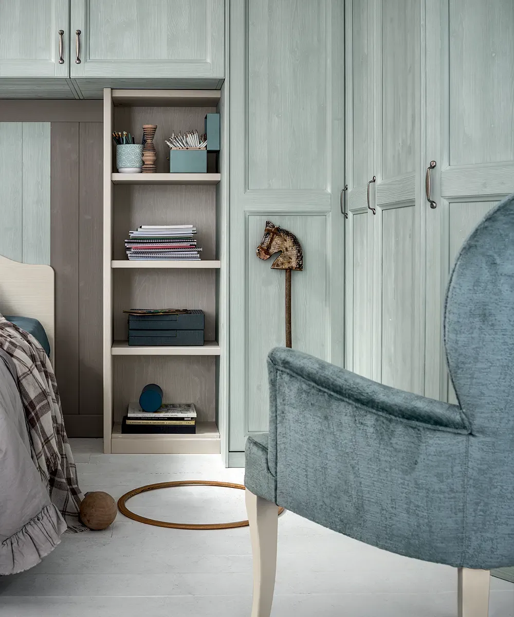 Libreria composta con pensili Athos accanto all’armadio, cameretta Everyday Luna Callesella