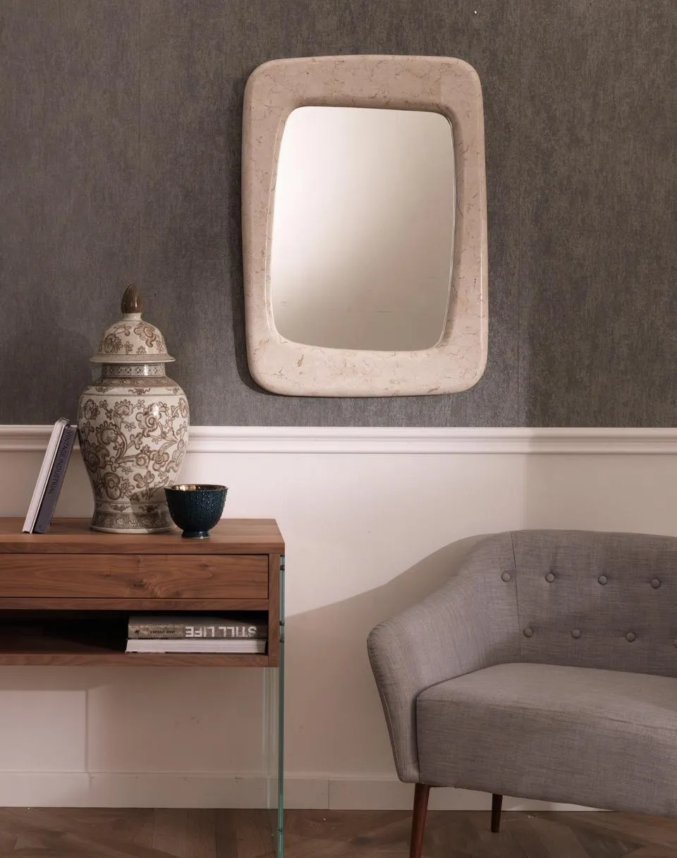 Specchio Smooth Stones beige sopra una consolle in un soggiorno con divanetto grigio