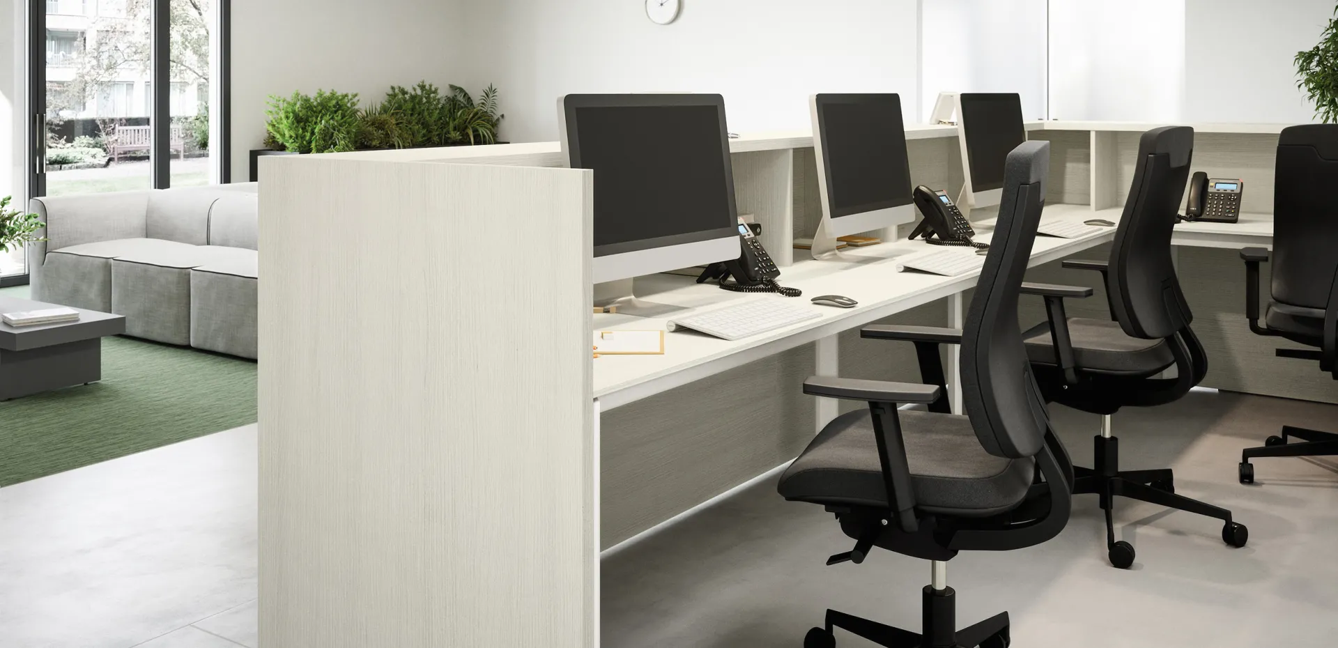 Bancone reception Cinquanta3 con postazioni di lavoro e computer dietro il banco