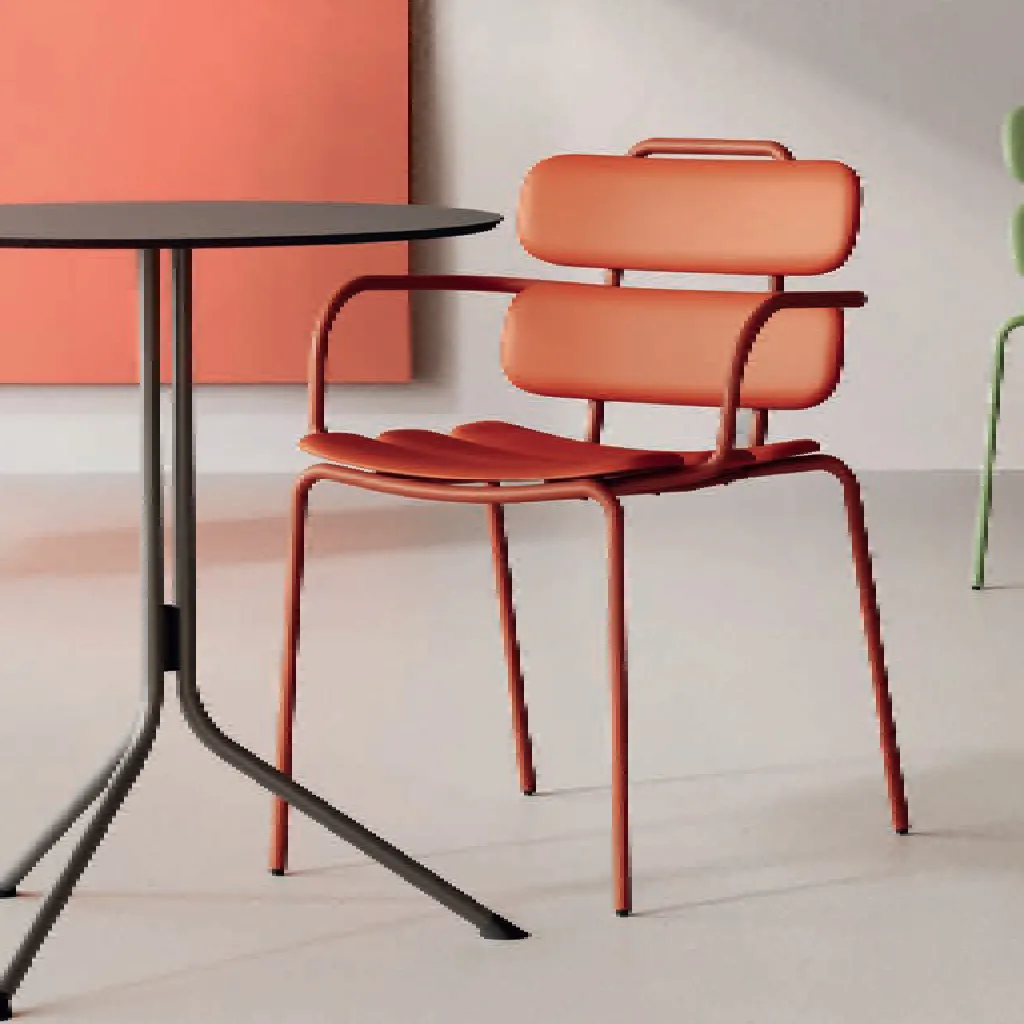 Sedia Lemon Unisit rosso mattone con braccioli accanto a un tavolino nero