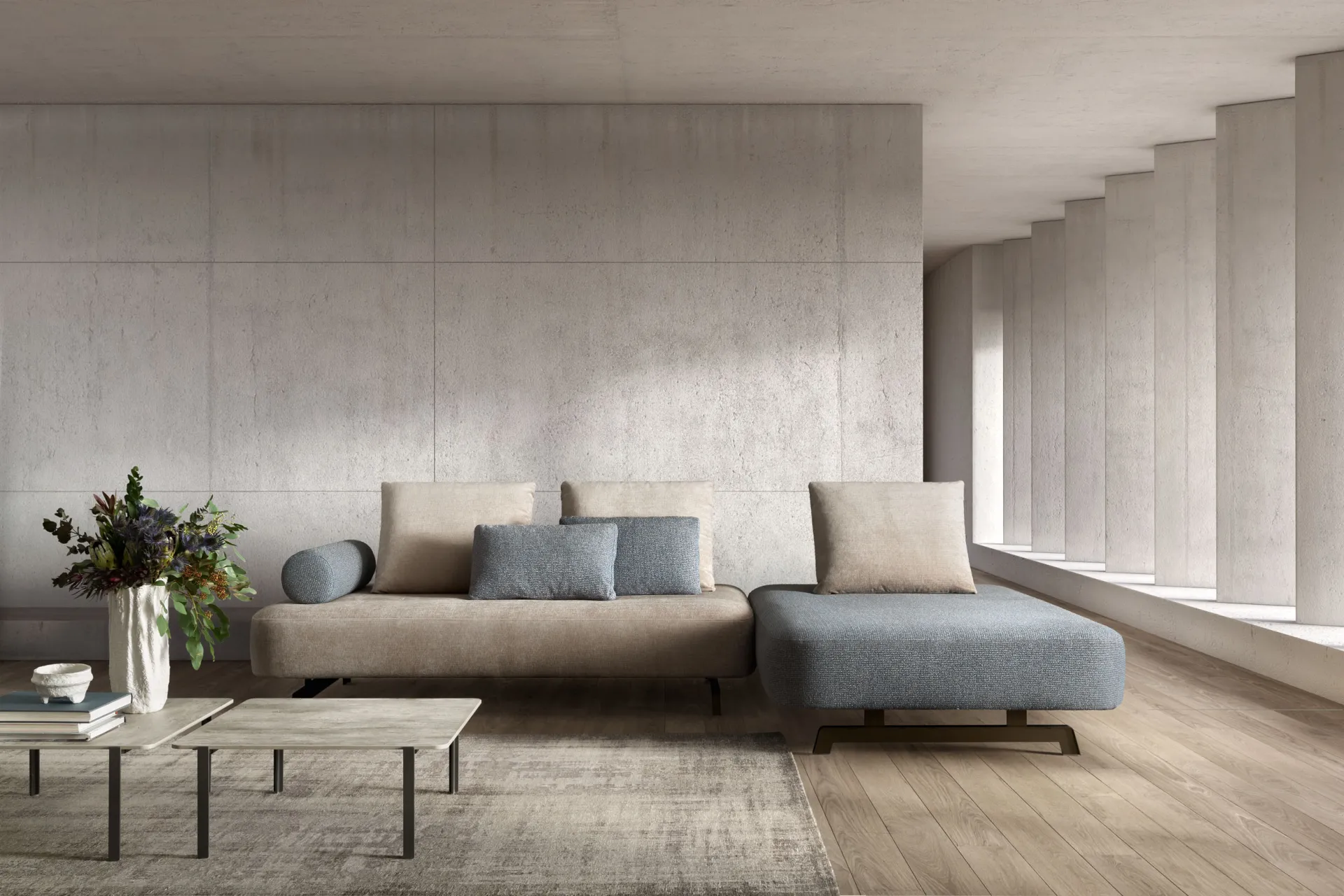 Divano modulare Matrix Samoa beige con chaise longue azzurra e tavolino basso, in un soggiorno luminoso