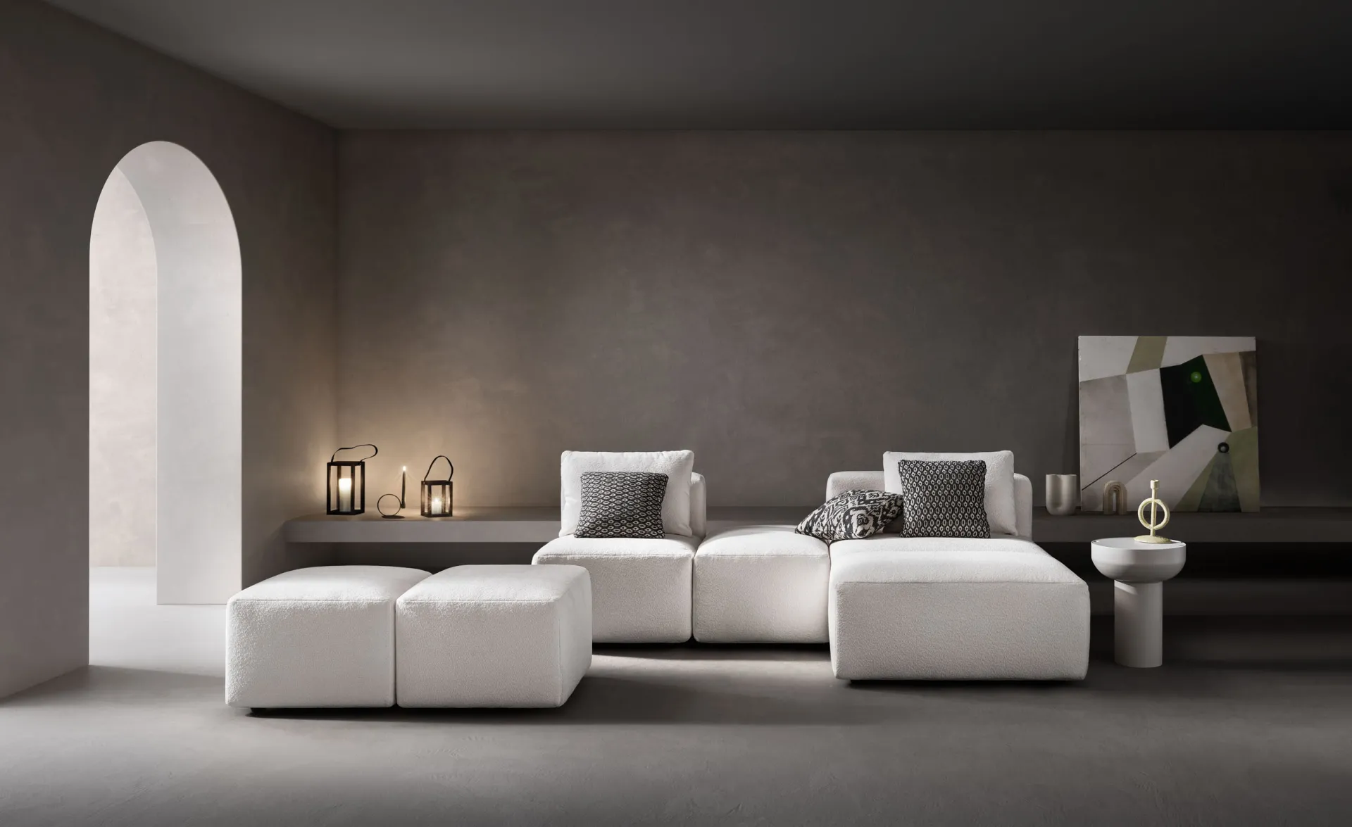 Divano modulare Sassy Samoa bianco in composizione con pouf separati, in un soggiorno con arco