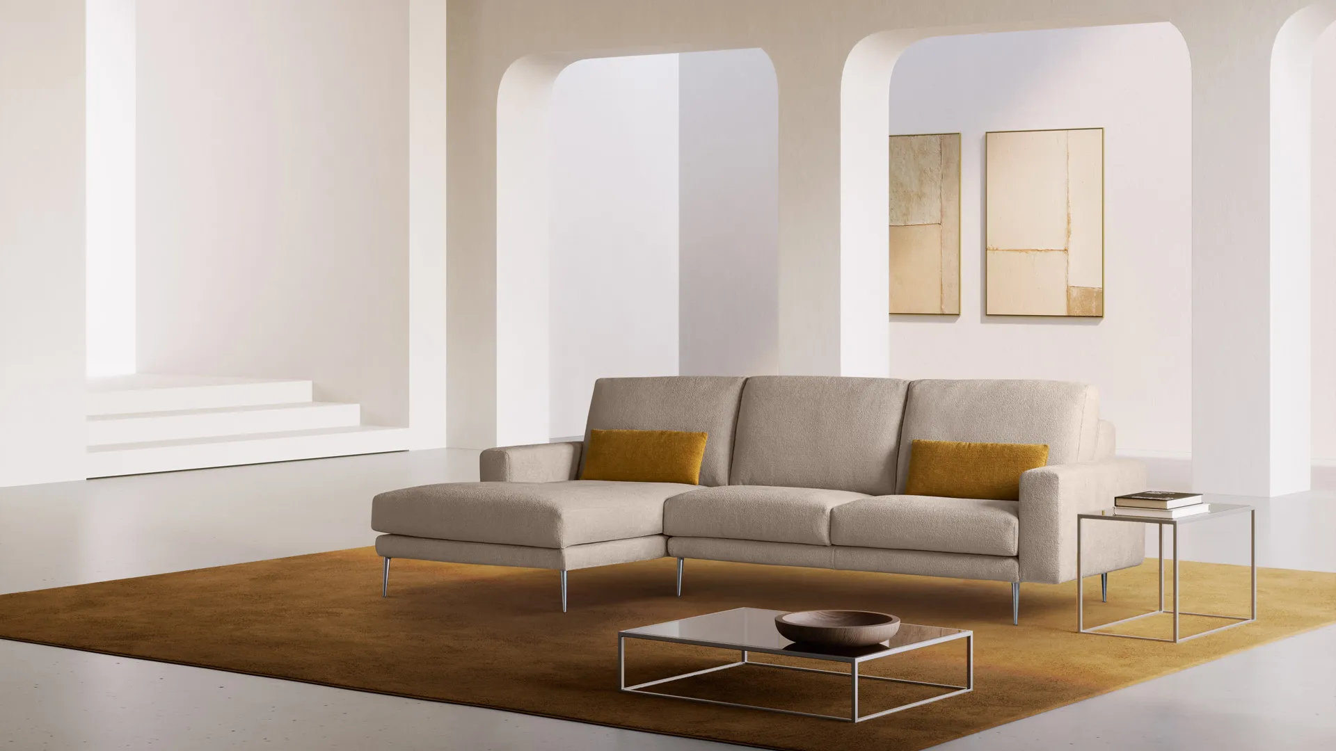 Divano Vittoria Aerre Divani beige con penisola su un tappeto ocra, in un ambiente con archi
