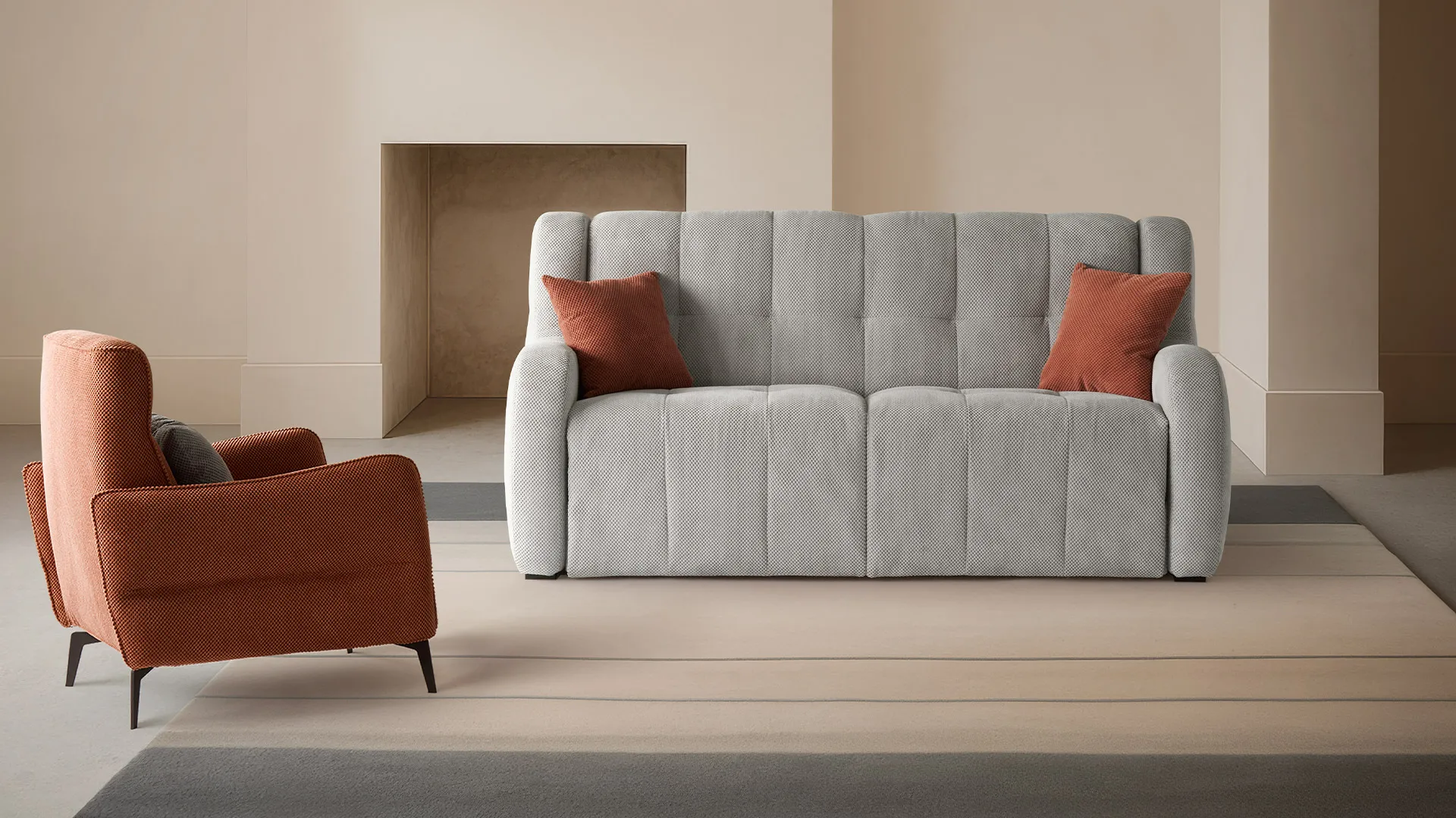 Divano letto Bloom Aerre Divani grigio con cuscini rossi e poltrona Parker arancio davanti al camino