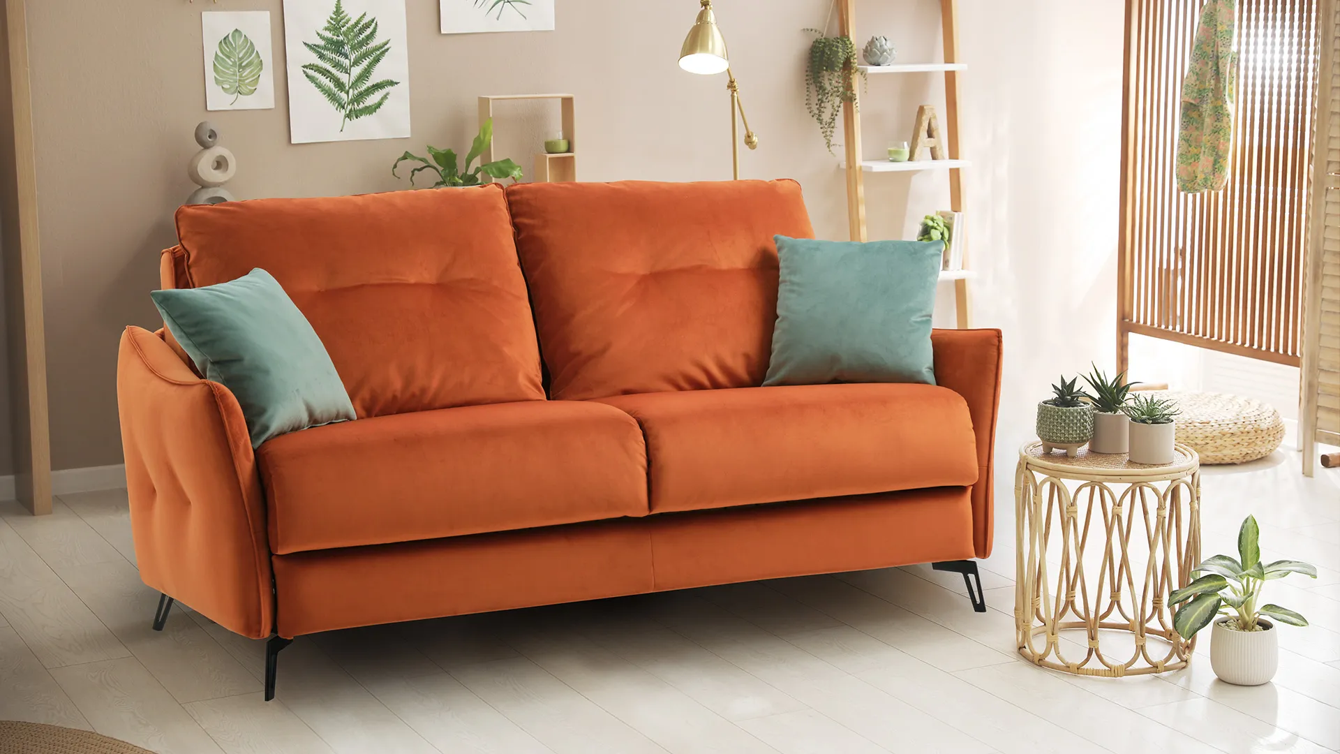 Divano letto Morgan Aerre Divani arancio con cuscini verdi tra piante e tavolino in rattan