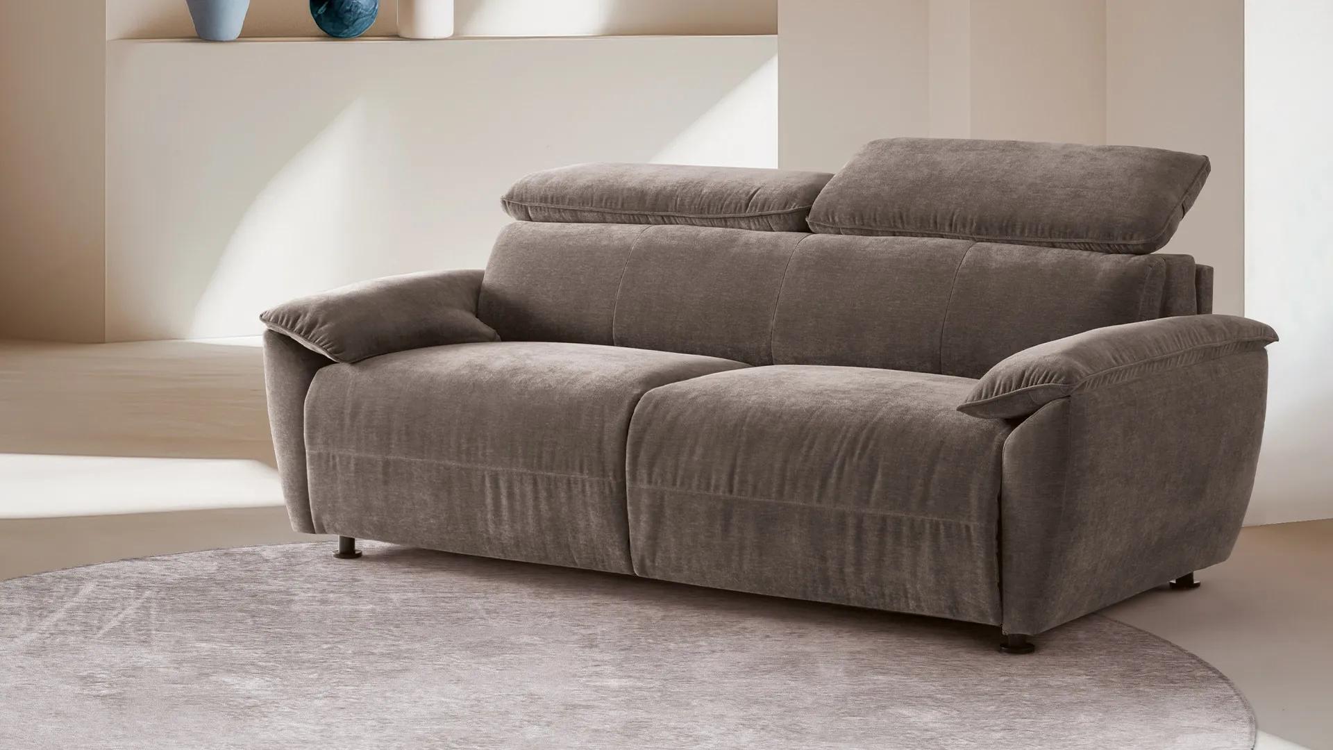 Divano letto Mimosa Aerre Divani grigio talpa con poggiatesta alzati su tappeto chiaro