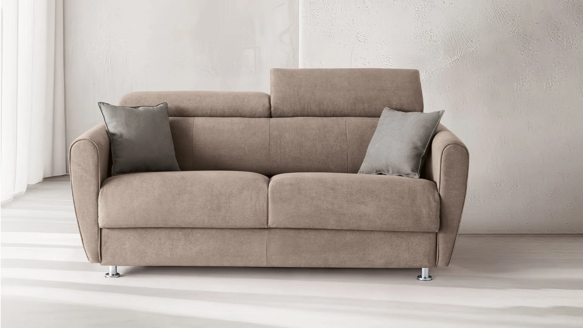 Divano letto Gina Style Aerre Divani tortora con poggiatesta alzati in un soggiorno chiaro