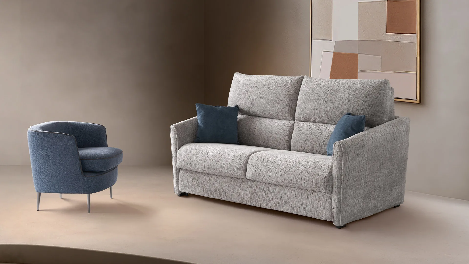 Divano letto Guenda Aerre Divani grigio chiaro con poltrona Zeno blu in un ambiente beige