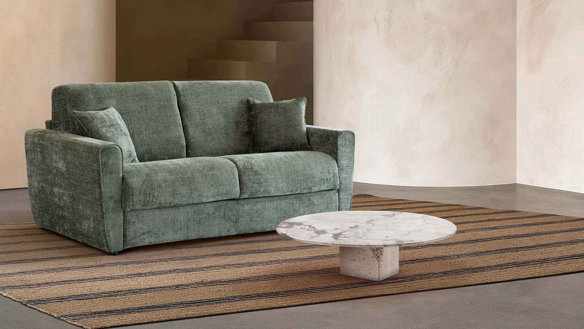 Divano letto Gianna Aerre Divani verde salvia con tavolino in marmo su tappeto a righe
