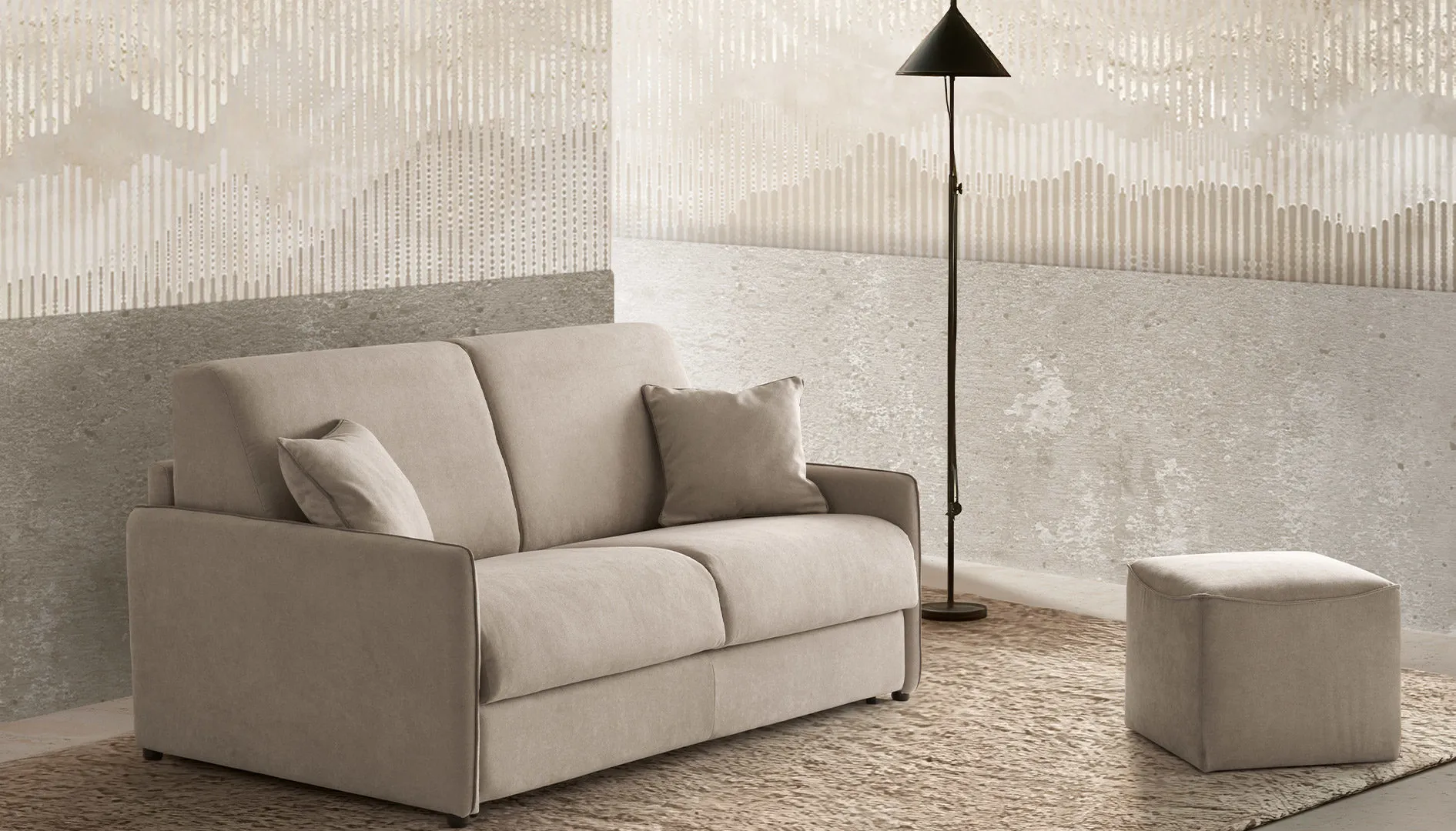 Divano letto Gloria Aerre Divani tortora con pouf Cube e lampada da terra, parete in pietra