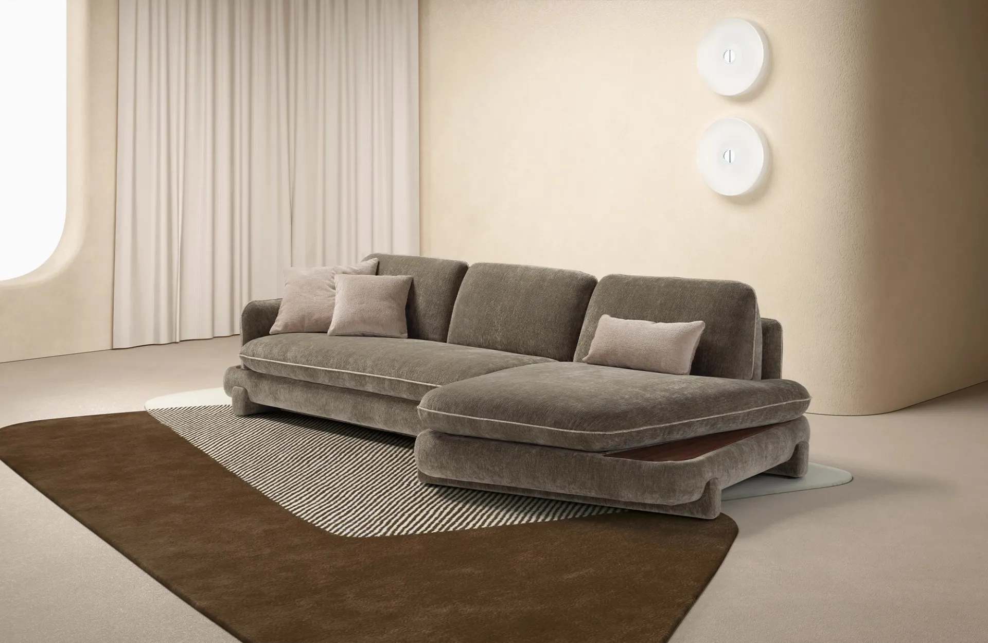 Divano letto Alma Dienne verde salvia con chaise longue tonda in un soggiorno con tende chiare