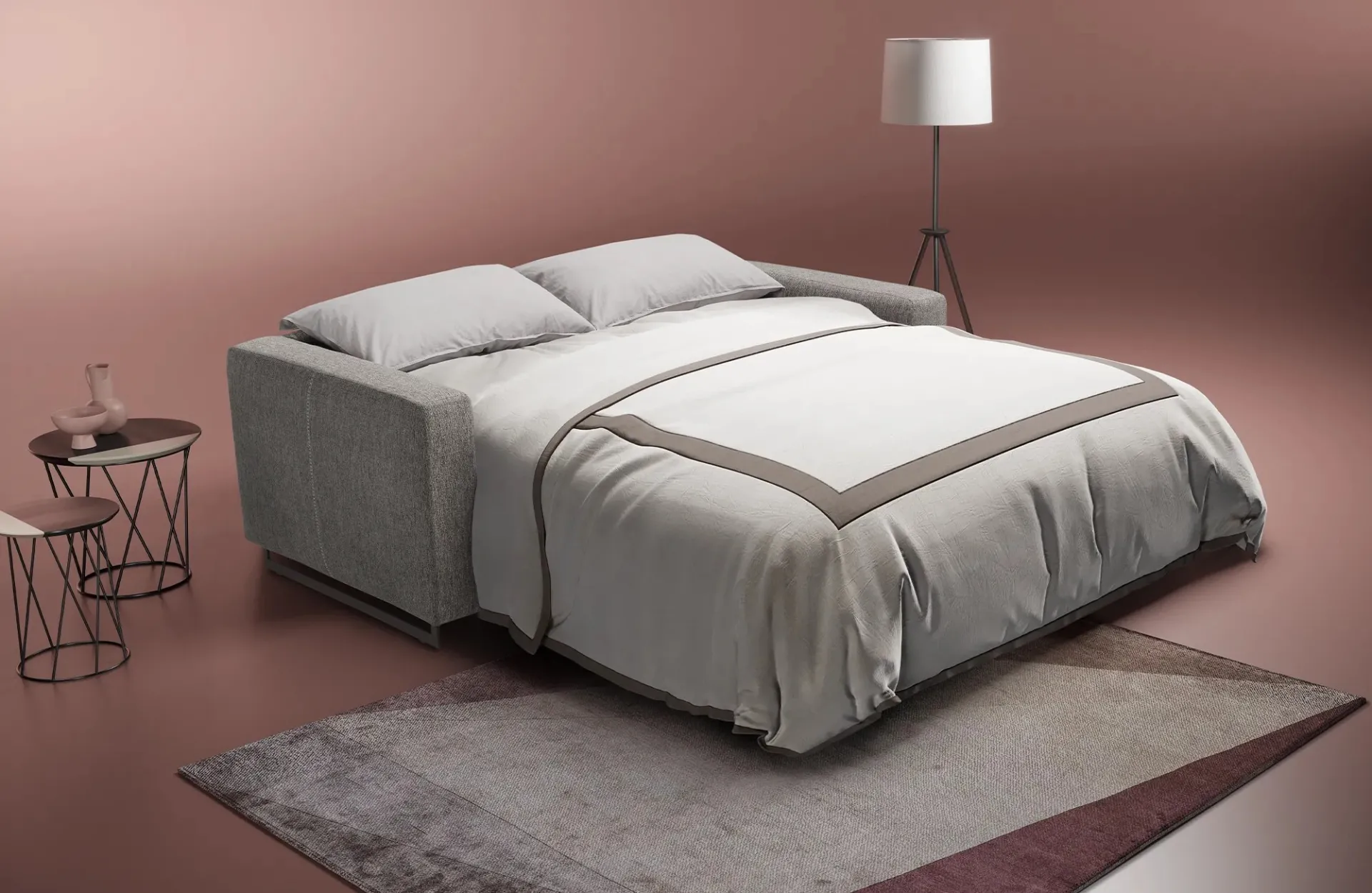 Divano letto Modular Pro Dienne aperto con lenzuola bianche in un ambiente rosa antico