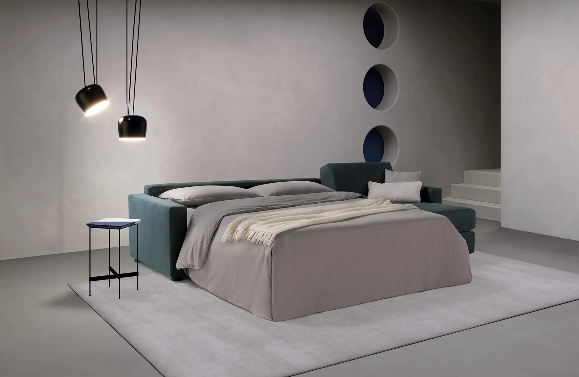 Divano letto Amsterdam Dienne con penisola e letto aperto, rifatto con lenzuola grigie