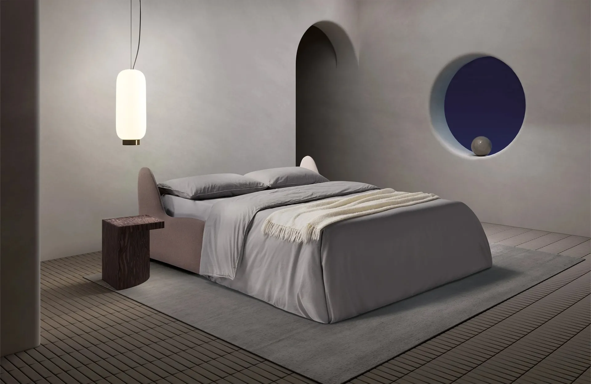 Divano letto Sax Dienne aperto di notte con lenzuola grigie e coperta crema