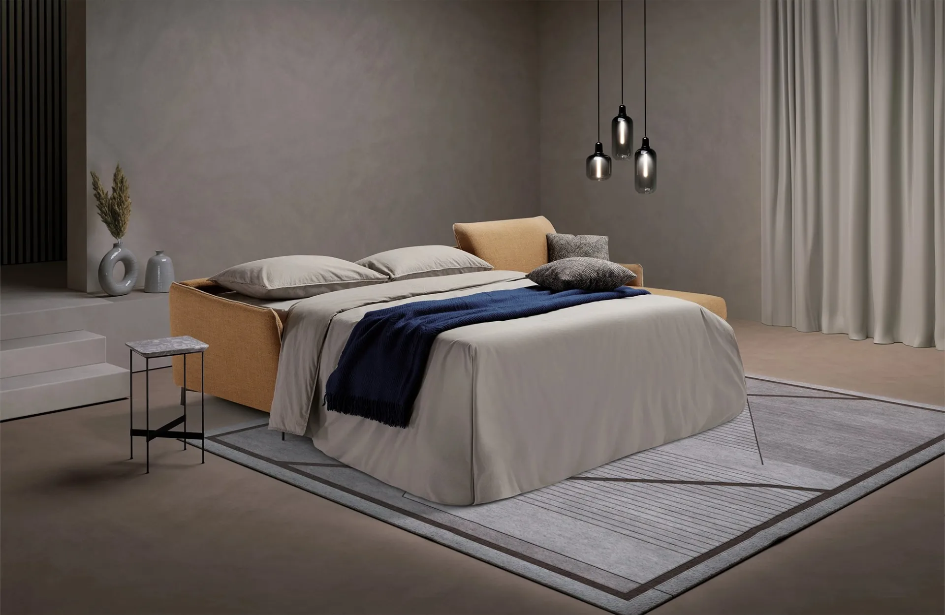 Divano letto Valentina Dienne aperto di sera, con coperta blu sul letto