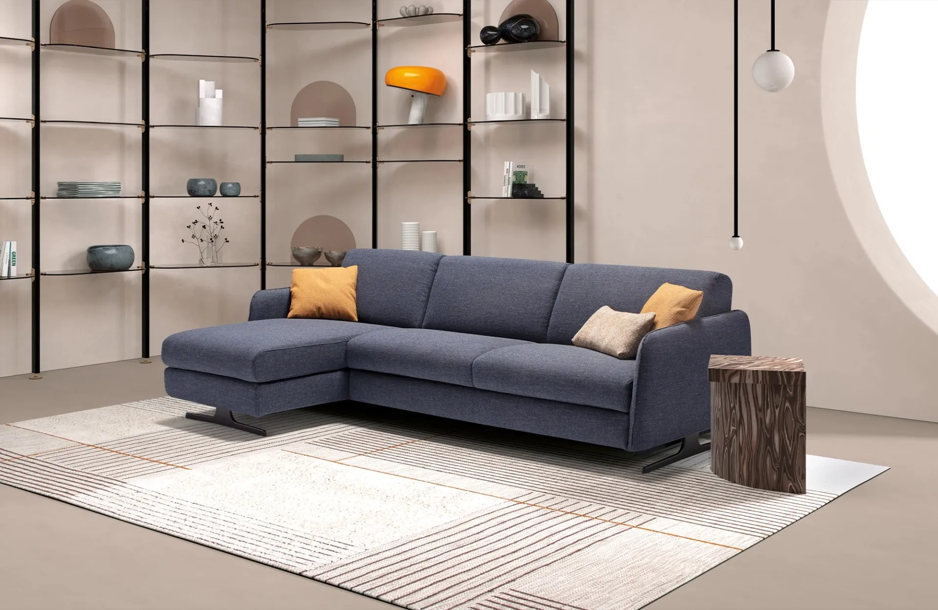 Divano letto Revival Dienne grigio blu con chaise longue davanti a una libreria metallica
