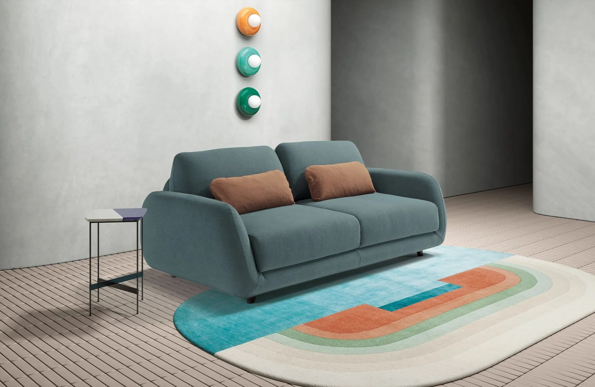 Divano letto Dodo Dienne verde acqua con poggiareni terracotta su un tappeto pastello