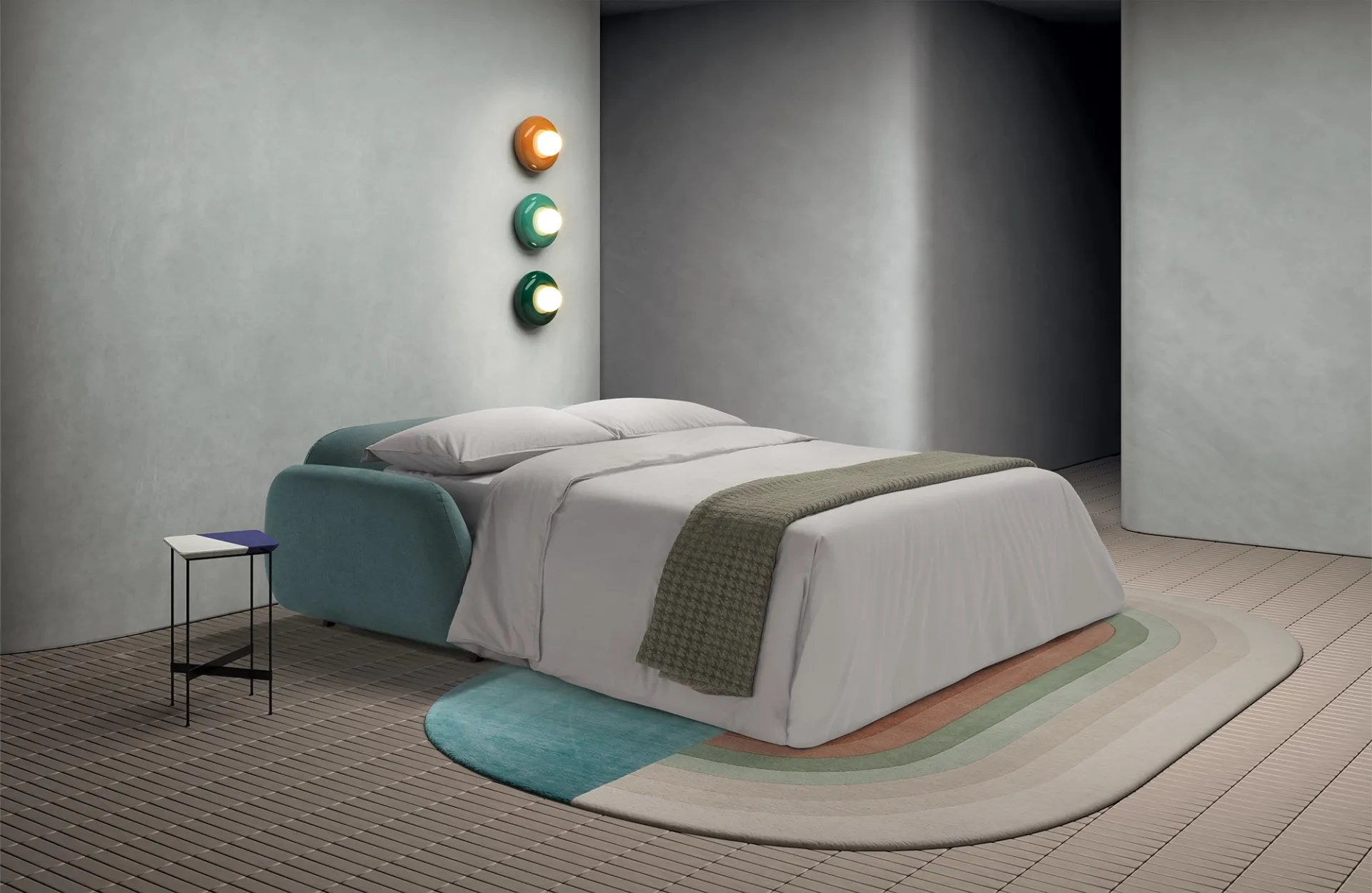 Divano letto Dodo Dienne aperto con lenzuola chiare e coperta verde