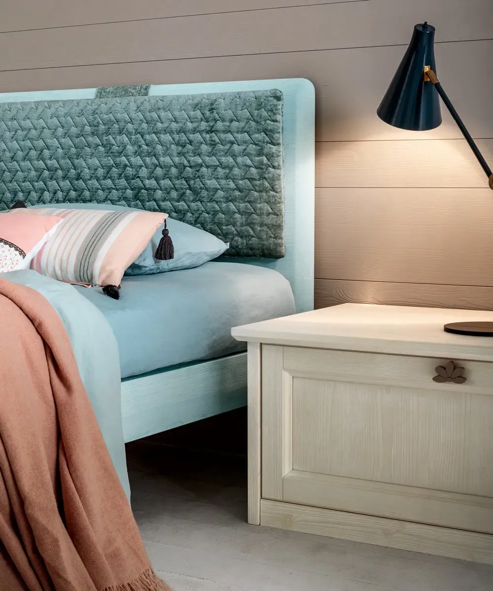 Letto Stella Callesella con testiera a cuscino azzurro e base-comodino con cassetto