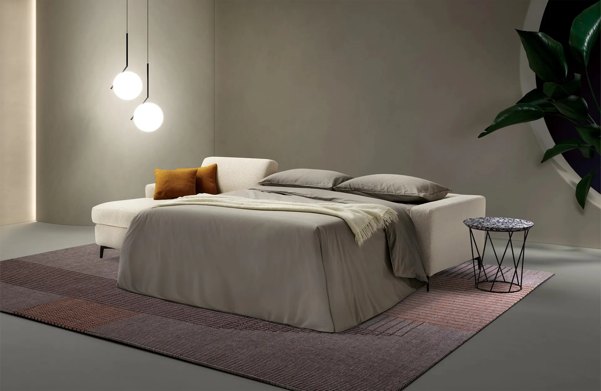 Divano letto Lisbona Dienne con penisola e letto aperto in luce serale